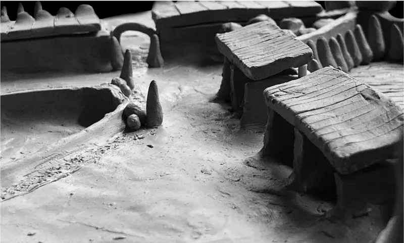 Close-up of a physical model showing vaulted roofs, stepped terraces and a miniature figure in shadow