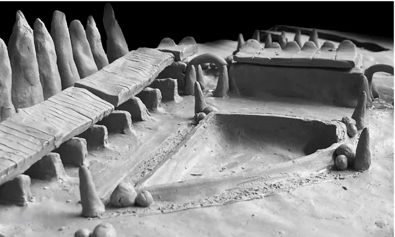 Detail of a clay model showing courtyards, vaulted structures and conical forms with dramatic raking light