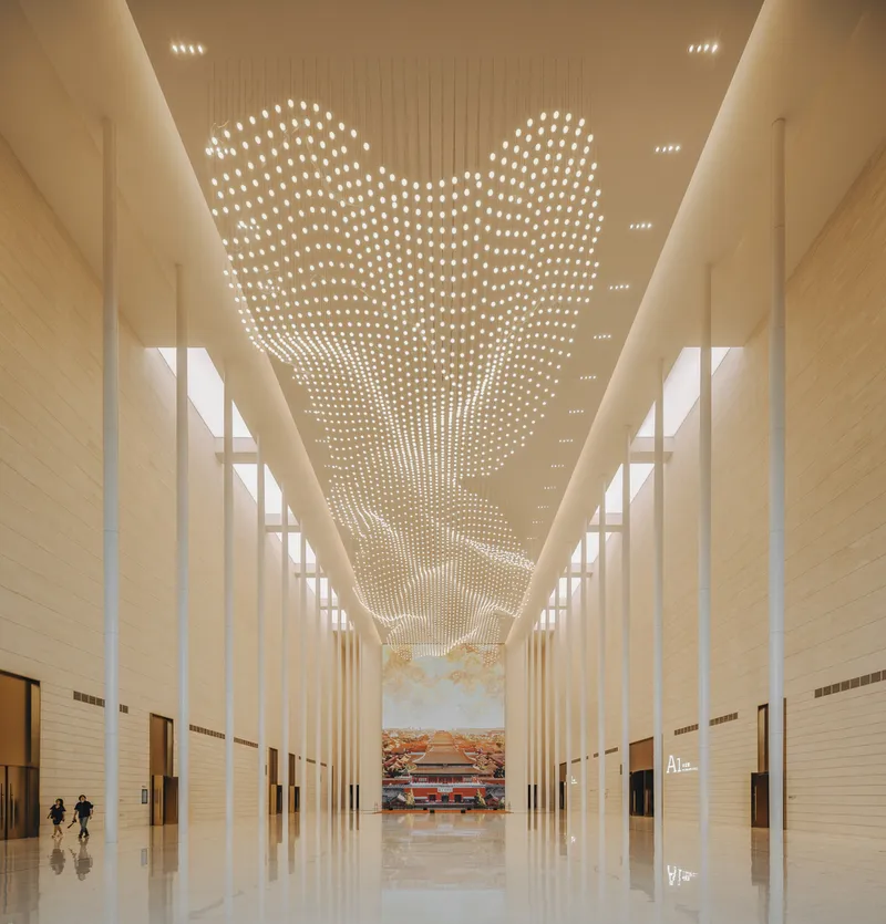 Tall lobby corridor with perforated ceiling lights and two figures walking on polished floor