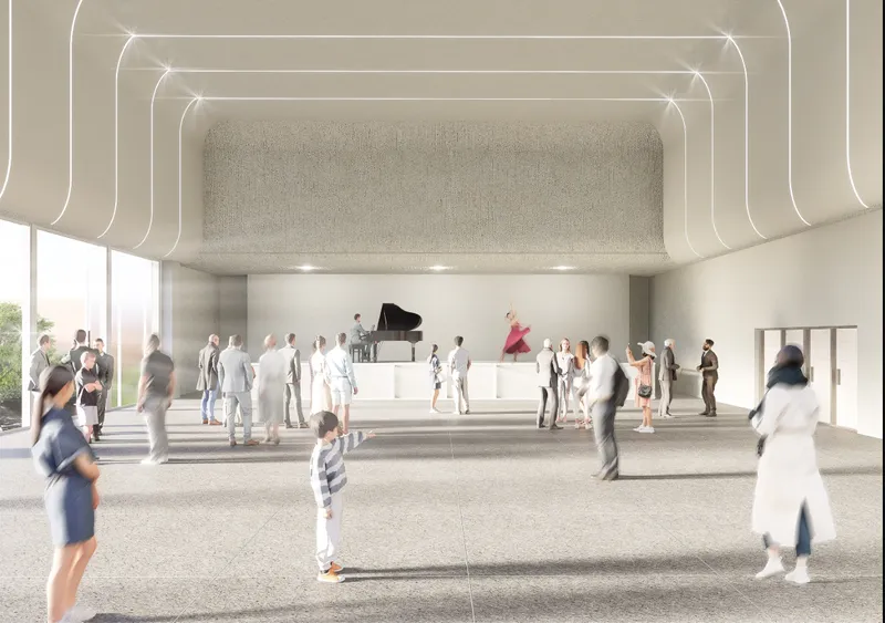 Performance hall with grand piano on raised platform and layered ceiling bands with recessed lighting