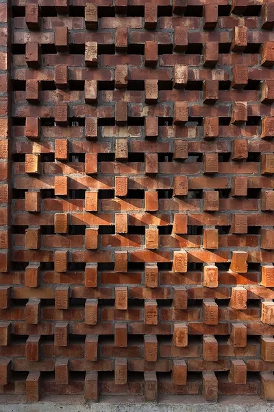 The image showcases a brick facade with a distinctive openwork pattern. The bricks are arranged in a