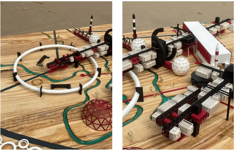 Physical model on plywood base showing curved white rail loop connecting modular blocks and dome elements