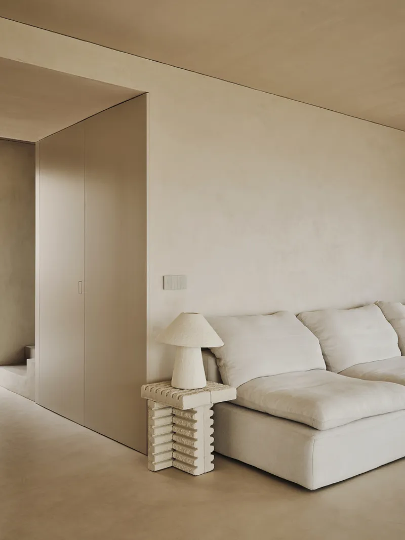 Interior corner showing flush wall panel detail beside seating area with ribbed side table
