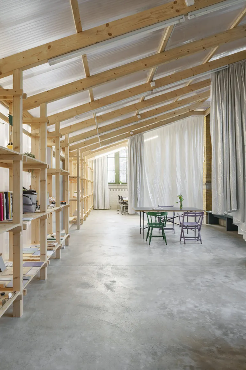 Interior with exposed timber frame ceiling and built-in shelving along polished concrete floor