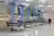 The image showcases a modern hospital ward with several patient beds neatly arranged in a row. Blue 