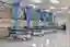 The image showcases a modern hospital ward with several patient beds neatly arranged in a row. Blue 