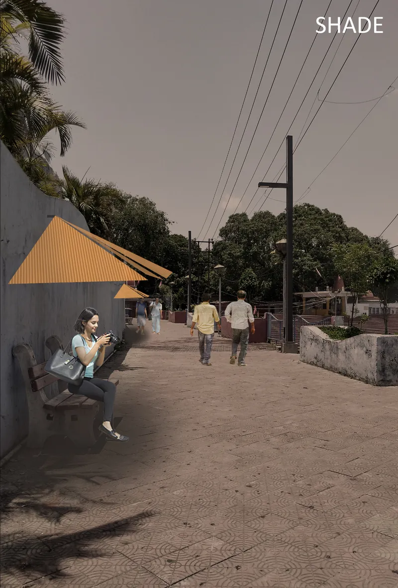Yellow triangular shade canopy beside a paved walkway where a woman sits on a bench