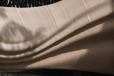 The image showcases a close-up of a draped fabric with a textured surface. The interplay of light an