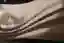 The image showcases a close-up of a draped fabric with a textured surface. The interplay of light an