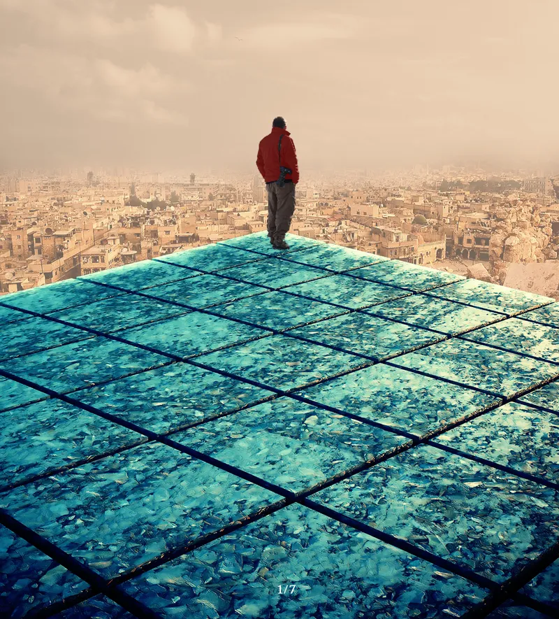 Rooftop view with person in red jacket standing on gridded turquoise glass panels above a dense cityscape