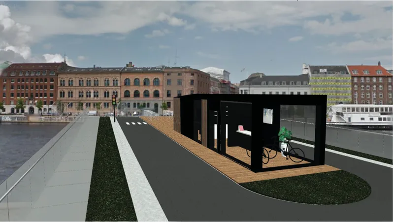 Black pavilion with glass walls and timber deck overlooking a harbor with boats under partly cloudy skies