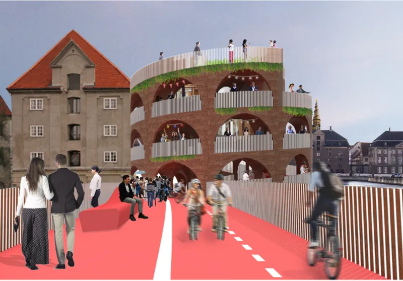 Elevated view of the red pedestrian pathway crossing the bridge deck with cyclists and visitors in motion