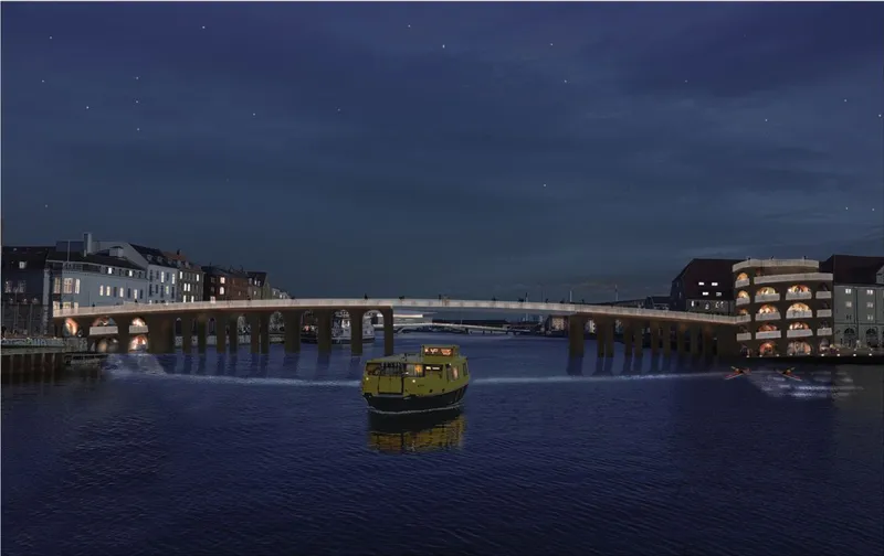 Night view of a pedestrian bridge spanning a harbor with lit arches and a small ferry crossing below
