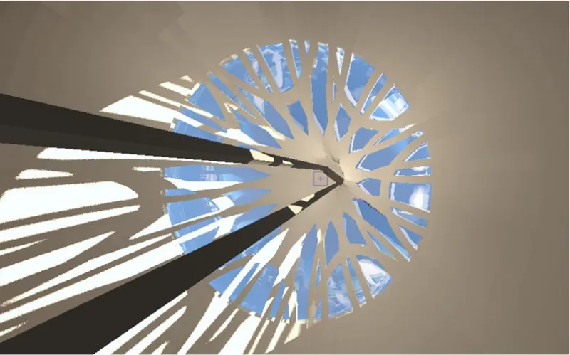 Upward view through the circular opening showing radial white structural fins against blue sky