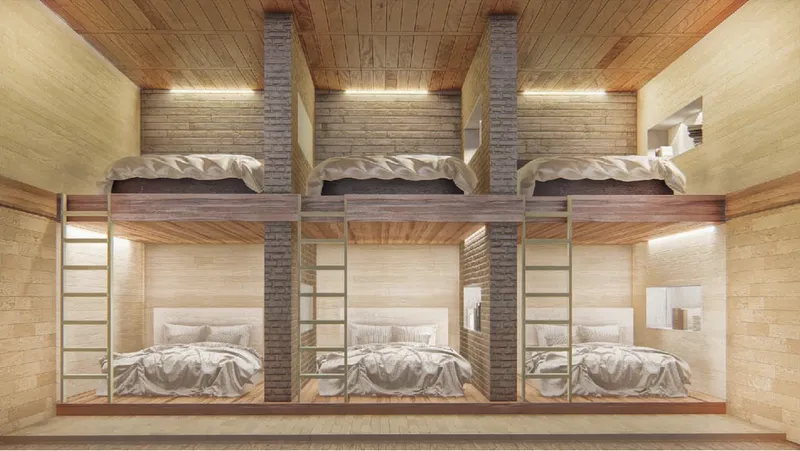 Timber-lined dormitory room with three bunk beds featuring ladder access and strip lighting above