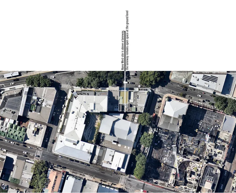 Aerial view of a central courtyard surrounded by white-roofed structures between street traffic and adjacent buildings