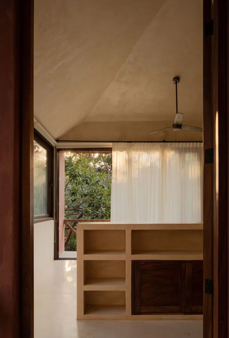 Interior room with built-in shelving and a translucent curtain beneath a vaulted plaster ceiling