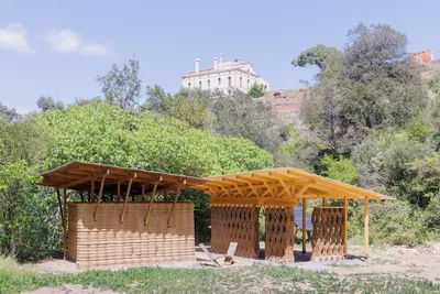 This architectural image showcases a sustainable design featuring earthen walls and a wooden structu