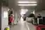 This photo depicts a long, cluttered corridor in what appears to be a storage area or warehouse. The