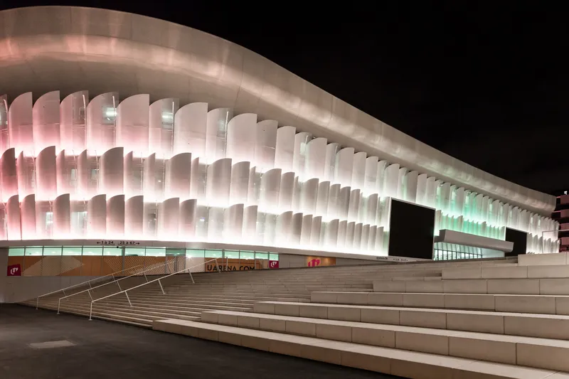 Exterior view of the layered fin facade with colored lighting above the entry plaza steps