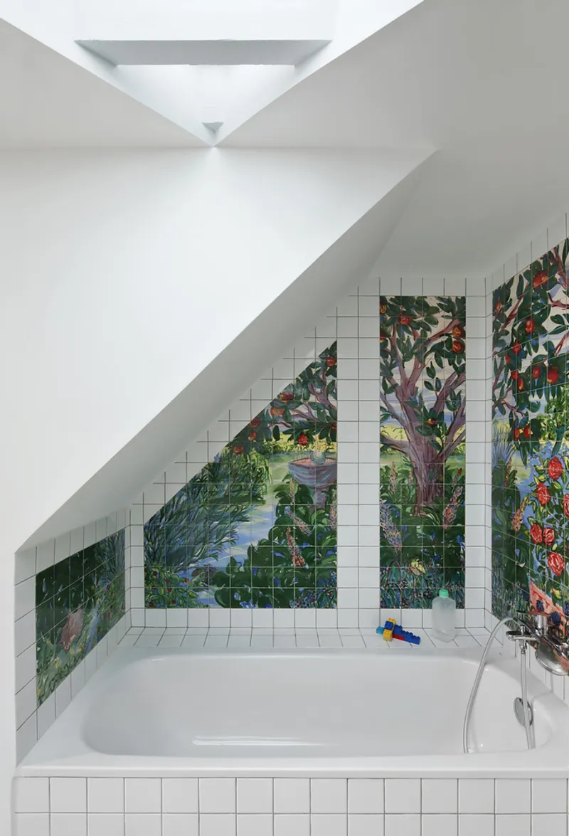 White tiled bathroom niche with tropical painted mural and a skylight above the tub