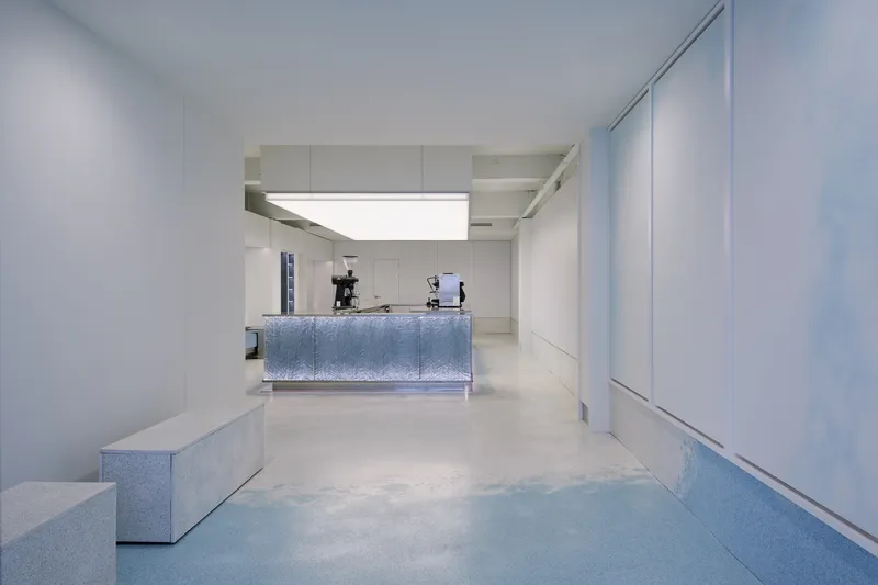 Interior view through white portal frames toward the illuminated service counter beyond