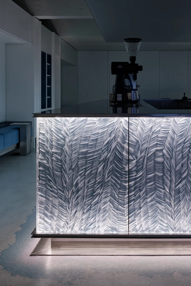 Close-up of the backlit counter with organic textured panel and coffee grinder above