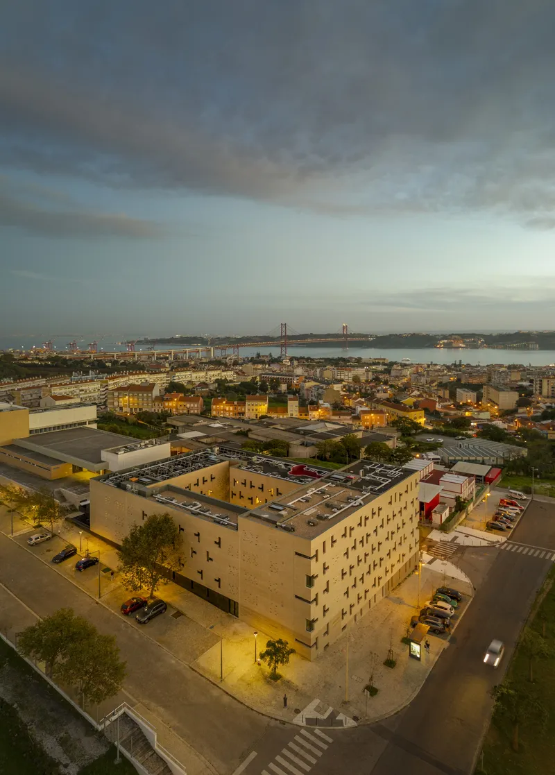 Aerial view of the rectangular brick housing block with central courtyard near the waterfront at dusk