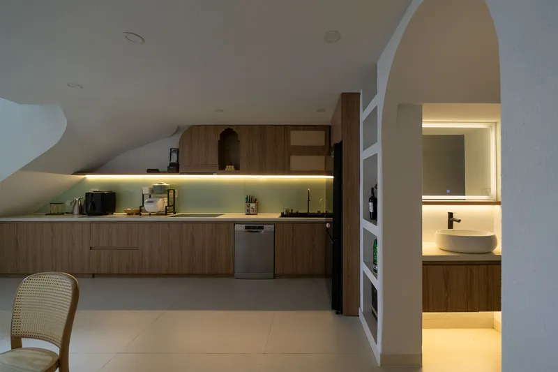Kitchen with timber cabinetry and LED strip lighting beneath upper cabinets at dusk