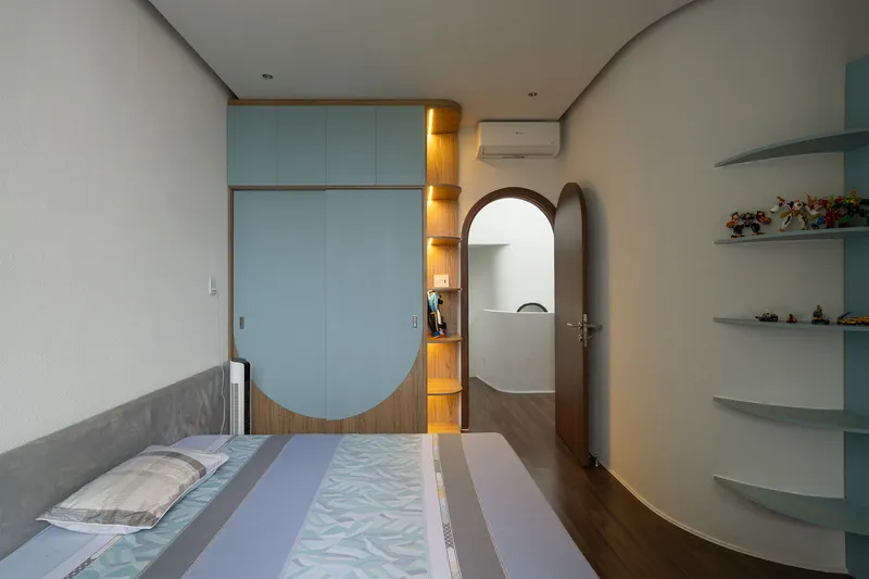 Bedroom with built-in wardrobe featuring arched timber accent and blue panels with integrated lighting