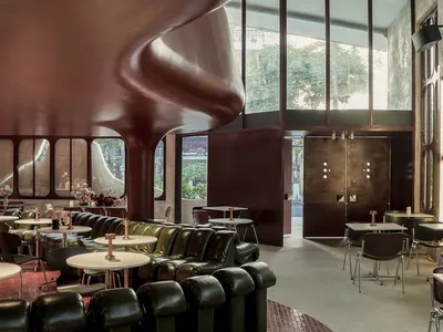 1.61 Design Workshop Wraps a 600-Square-Meter Café in Vietnam in Sculptural Burgundy Drama