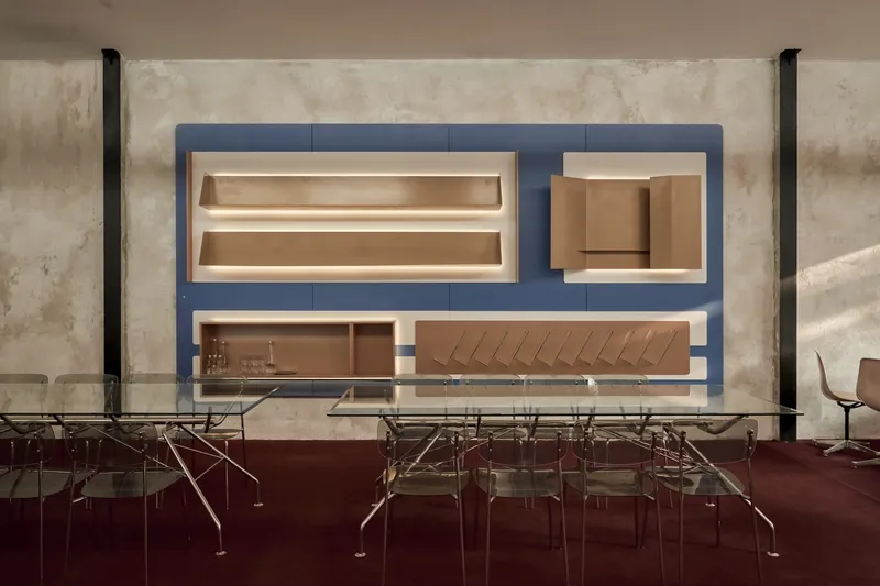 Frontal view of the bar counter with illuminated recessed shelving against blue paneling