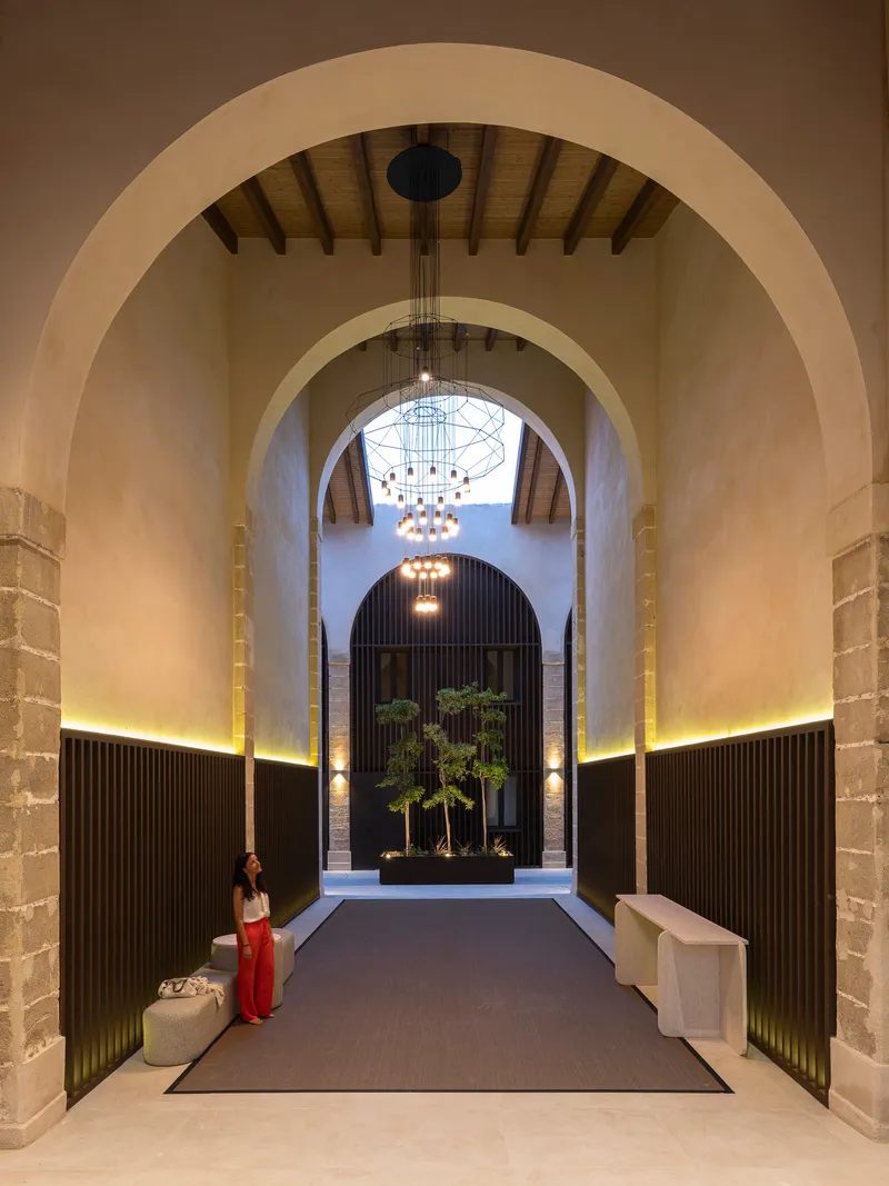 Vaulted entrance hall with tiered chandelier and a planted reflecting box