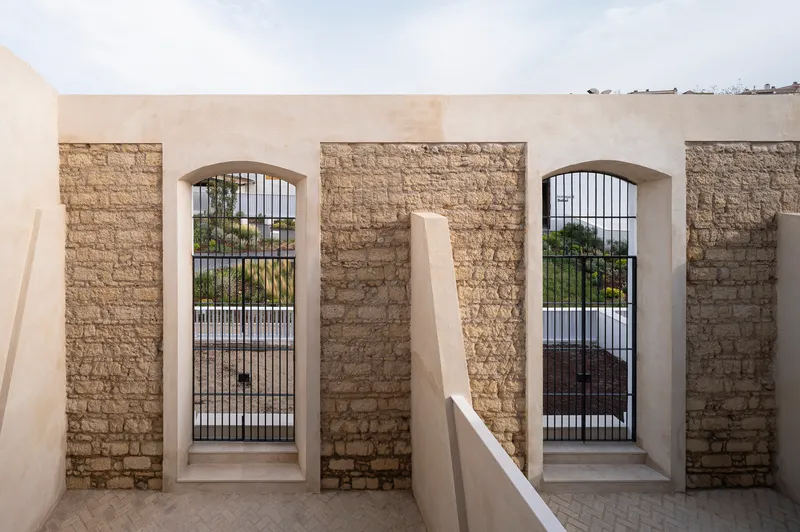 Roof terrace passage flanked by stone walls and arched openings