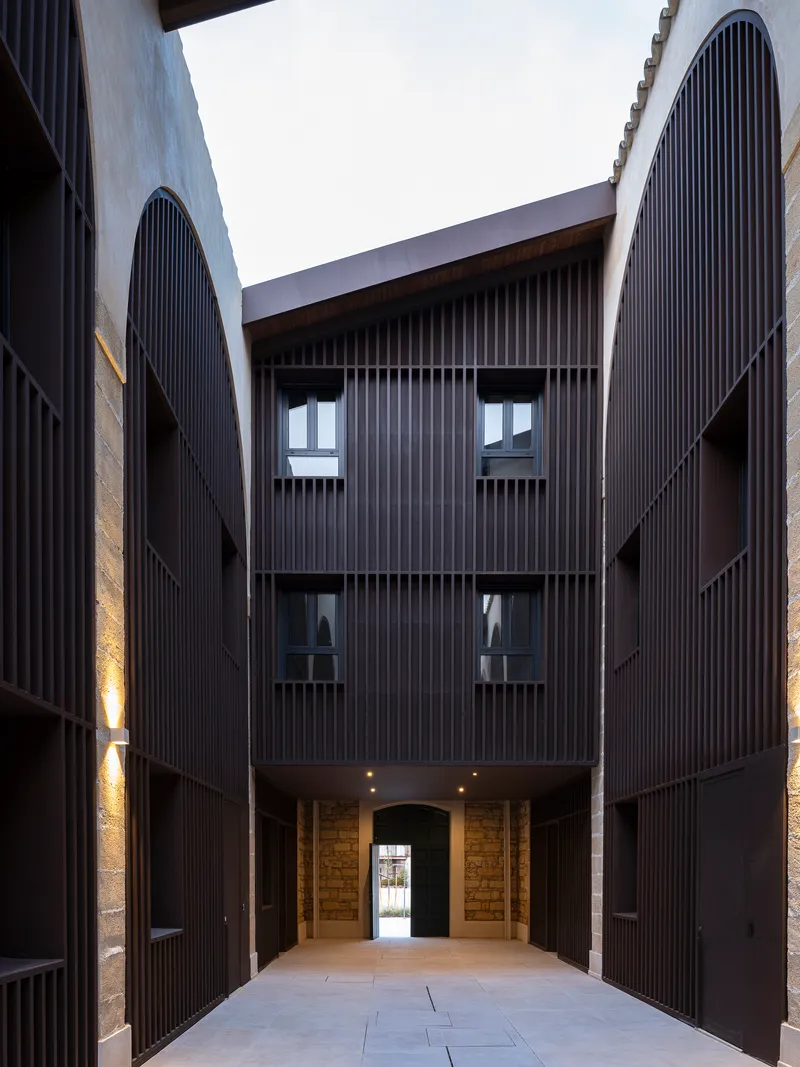 Three-storey timber-screened residential elevation inside a courtyard