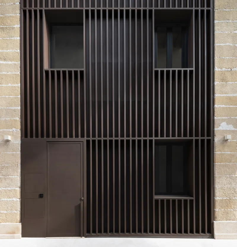Close-up of dark timber slat screen with recessed openings