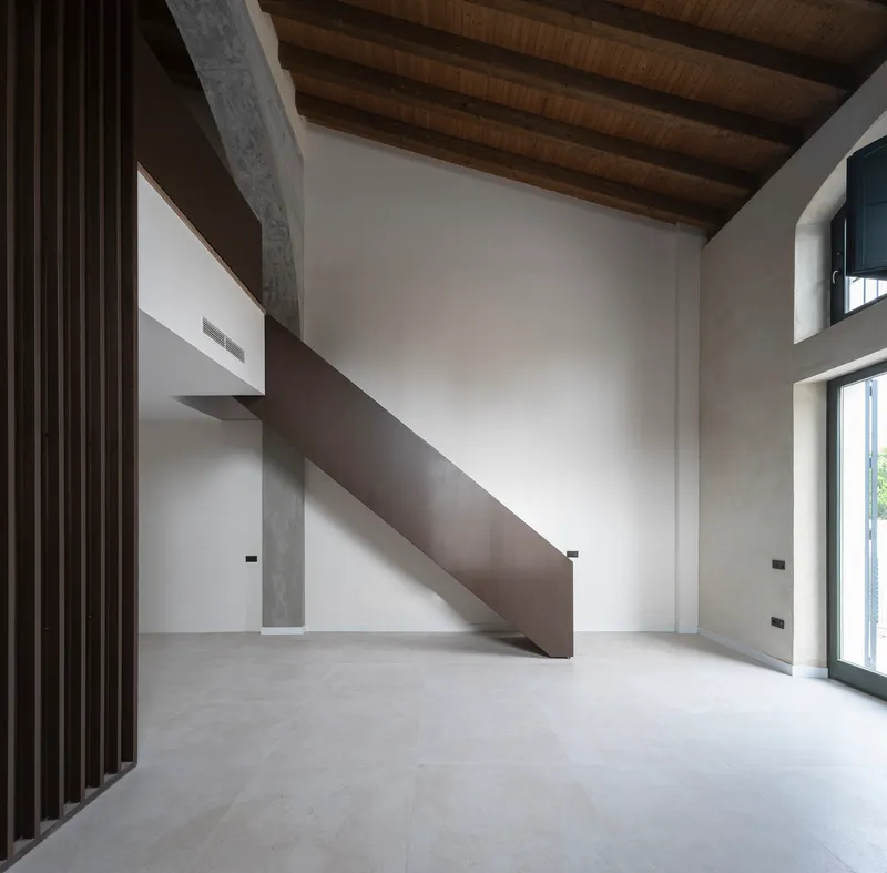 Double-height interior with original timber roof and a steel stair