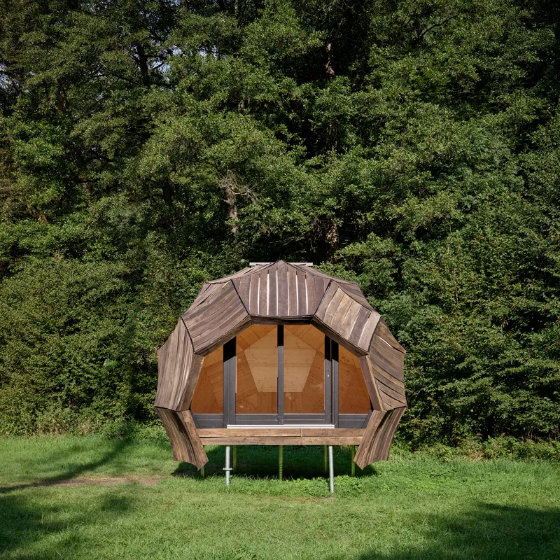 Front elevation of the faceted timber pavilion showing plywood door panels and metal standing seam roof