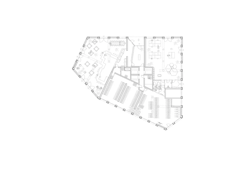 Floor plan drawing showing angled auditorium seating, cafe seating area, and circulation zones with stair cores