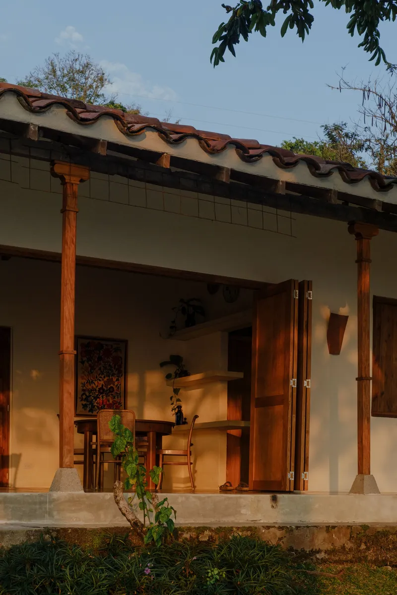 Exterior veranda with timber columns and terracotta roof tiles at dusk