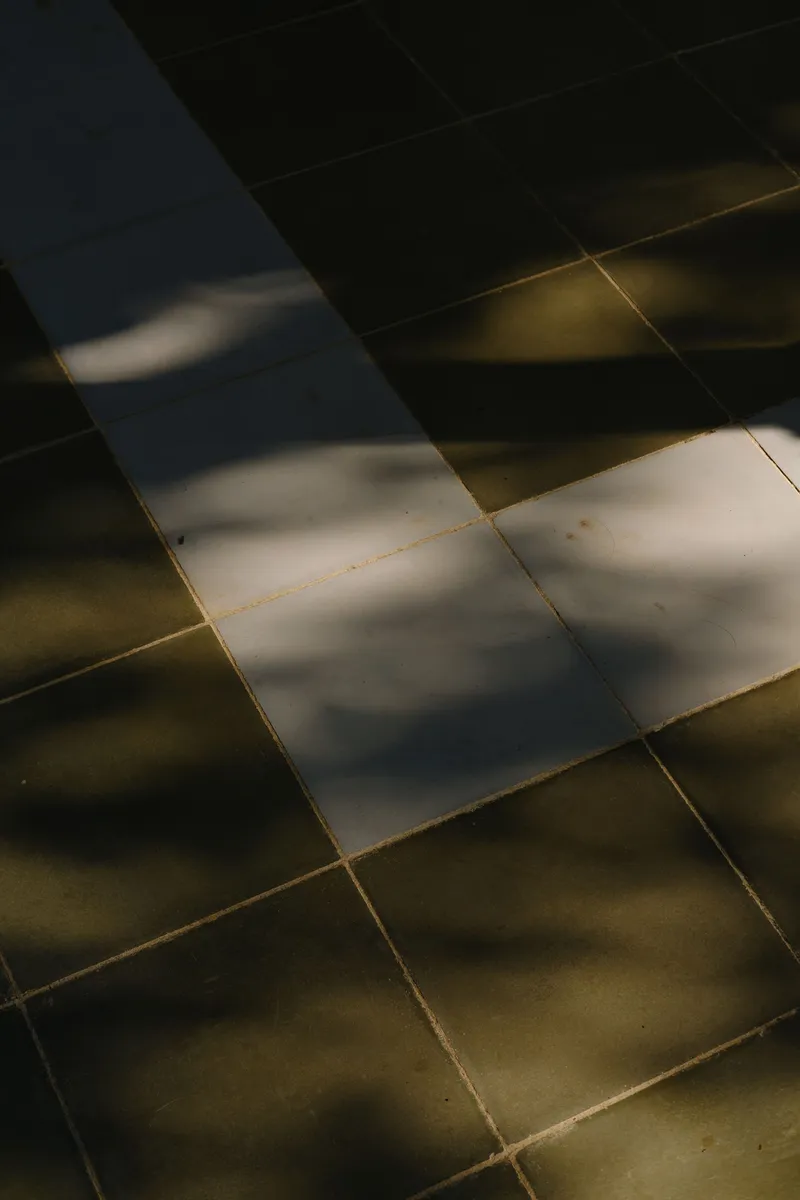 Diagonal shadows crossing a gridded stone floor in afternoon light