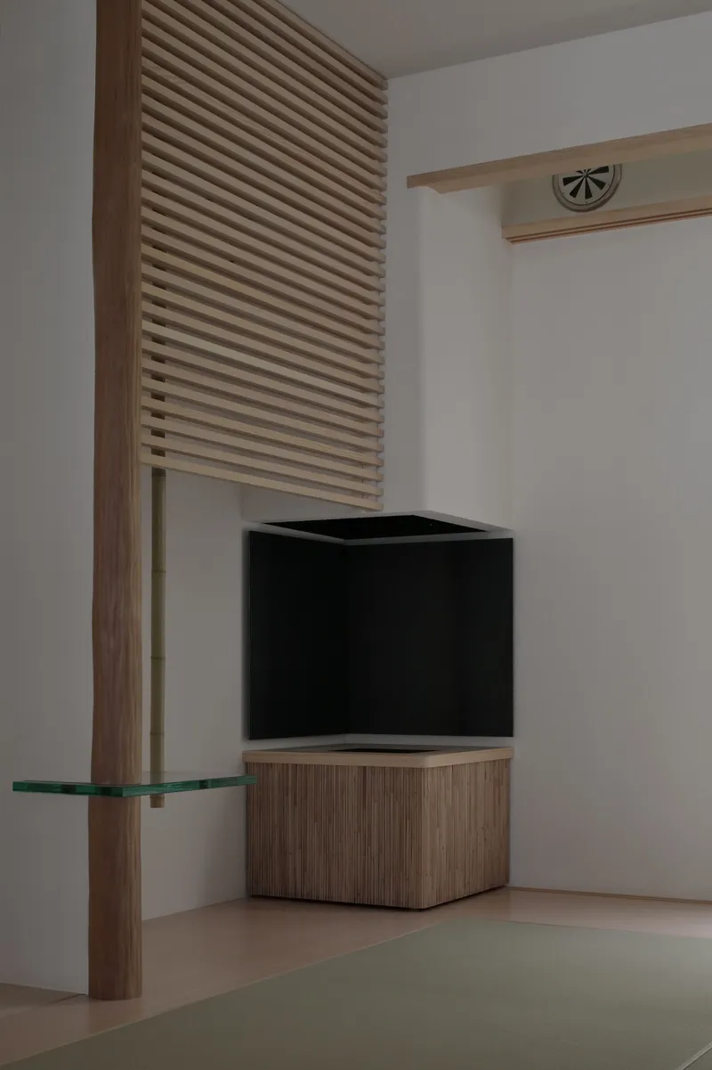 Corner detail with timber louvered panel, black metal box and glass shelf in white room