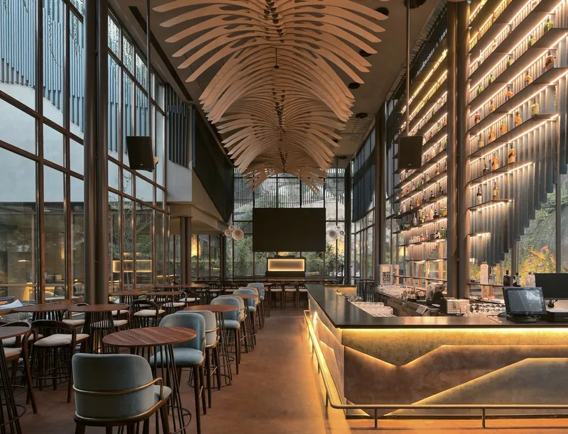 Interior dining hall with layered timber ceiling ribs and backlit bottle display wall