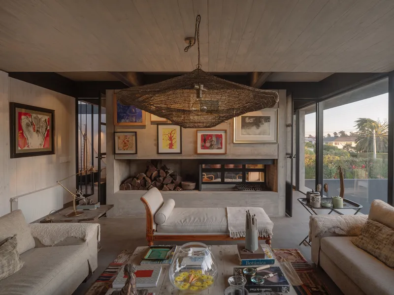 Living room with concrete fireplace surround and timber plank ceiling beneath a large woven pendant light