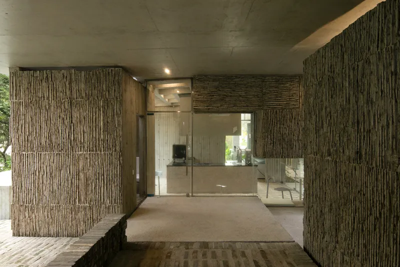 Entry corridor with ribbed timber walls and concrete ceiling beneath recessed lighting