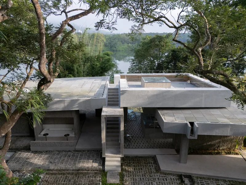 Terraced concrete roof decks with central staircase overlooking a distant lake through the tree canopy