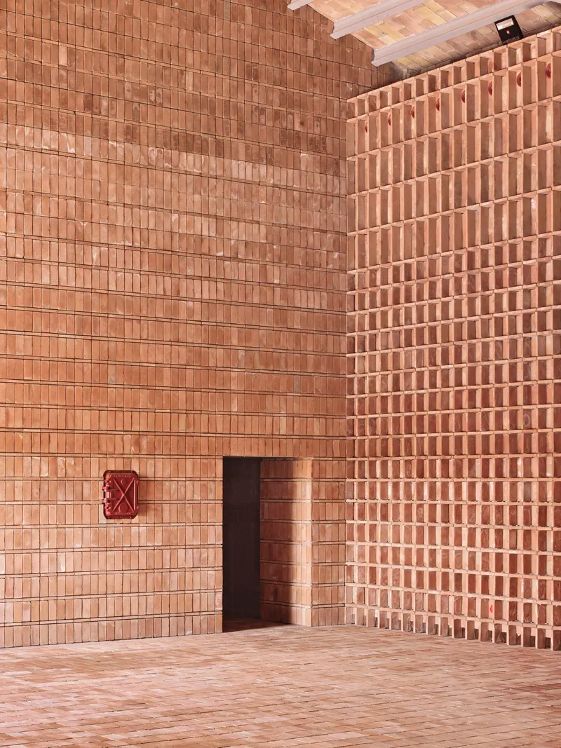 Corner view of doorway in terracotta brick wall with alternating open and solid coursing patterns
