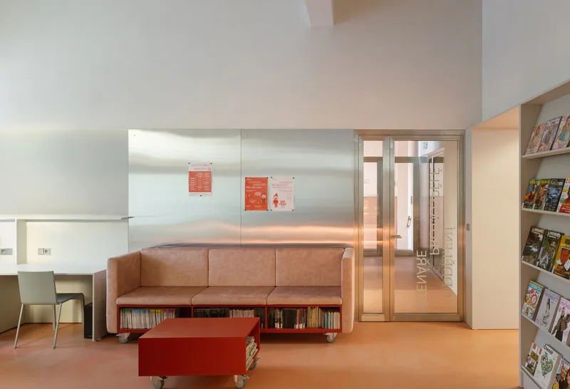 Tan leather sofa with book storage beneath and translucent glass partition beyond