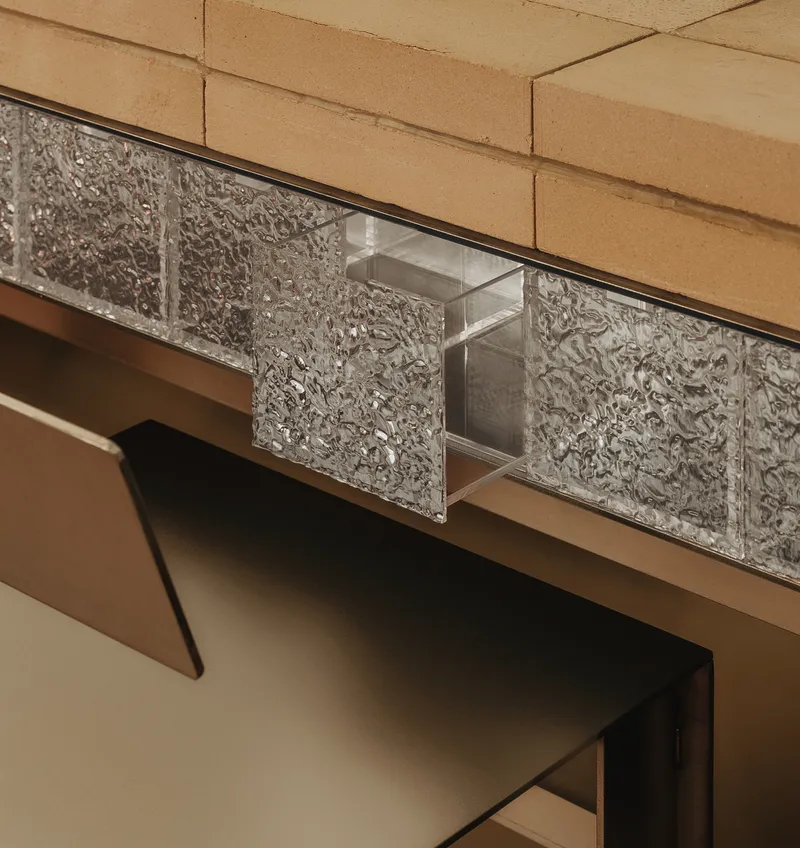 Close-up of textured glass block clerestory beneath beige tiled soffit and steel frame