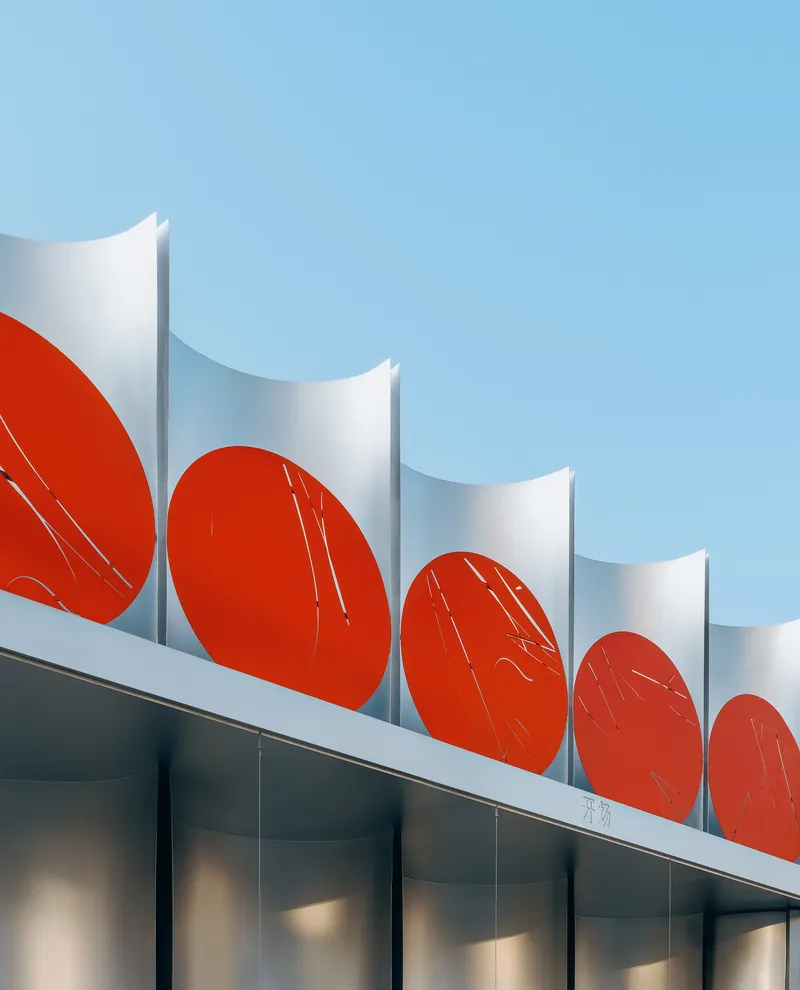 Roofline with white concave shells alternating with red circular panels against a clear blue sky